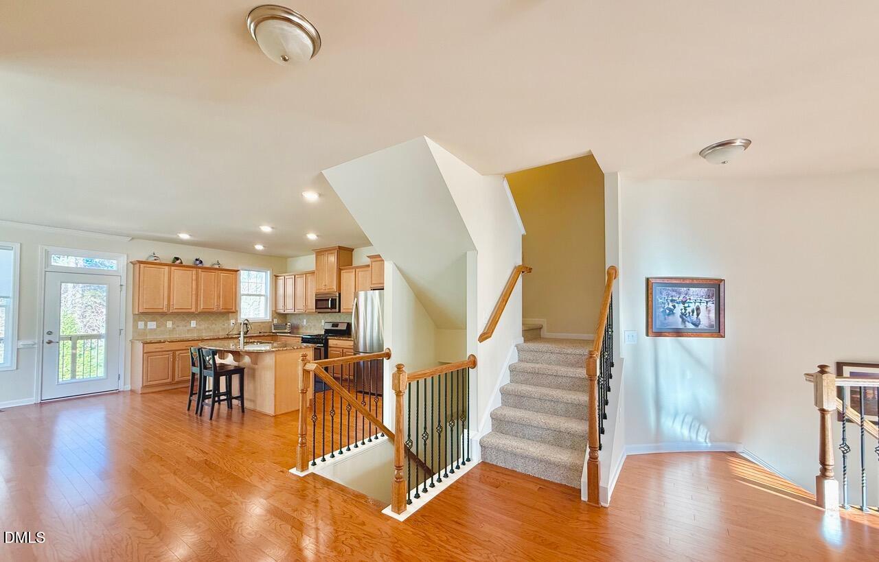 634 Edgewater Ridge Court Apex, NC 27523 - Photo 10 of 23 a view of a kitchen with dining room and wooden floor