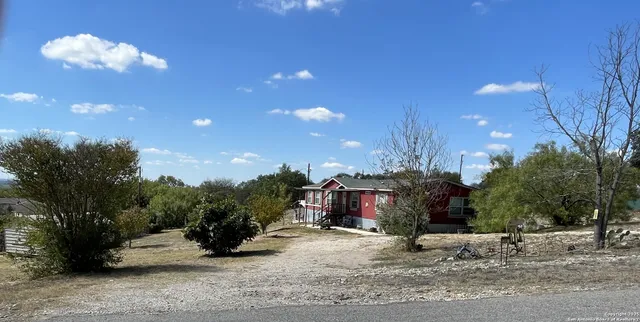 a view of a street with potted plants and large trees