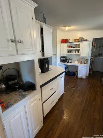 a kitchen with cabinets and wooden floor