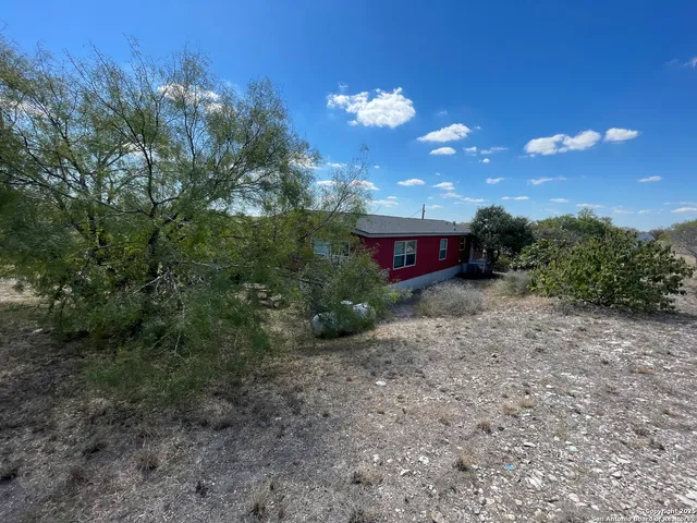 a view of a house with a yard and tree s