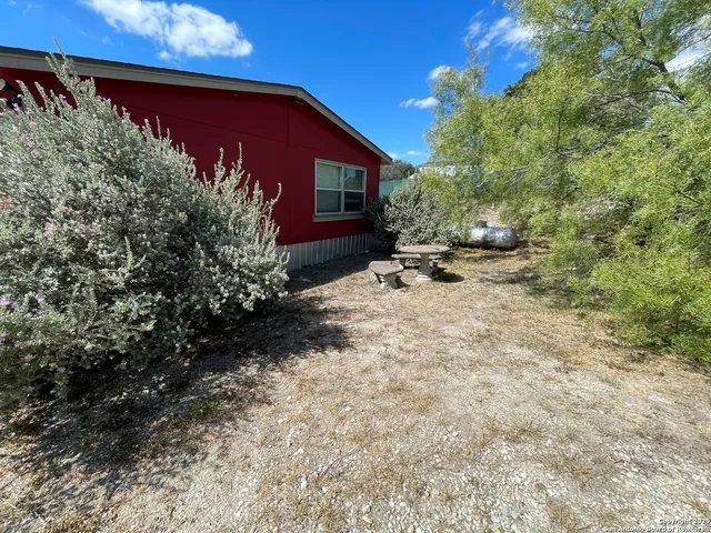 a view of a house with backyard and sitting area