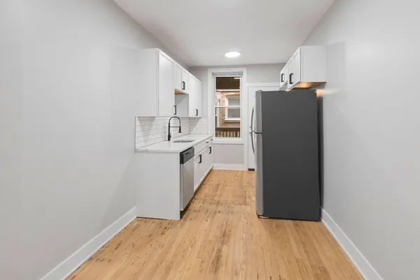 a view of a kitchen with wooden floor and electronic appliances