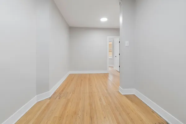 a view of a room with wooden floor and white walls