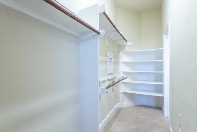 a view of walk in closet with empty racks