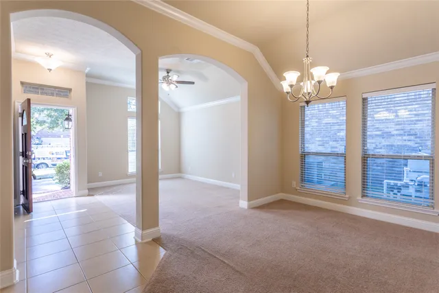 a view of an empty room with a fireplace and a chandelier