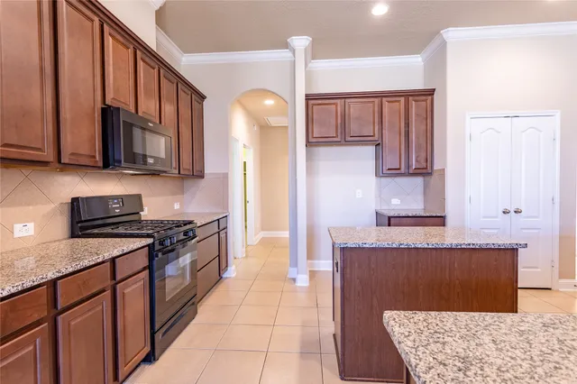 a kitchen with stainless steel appliances granite countertop a stove a sink and a microwave