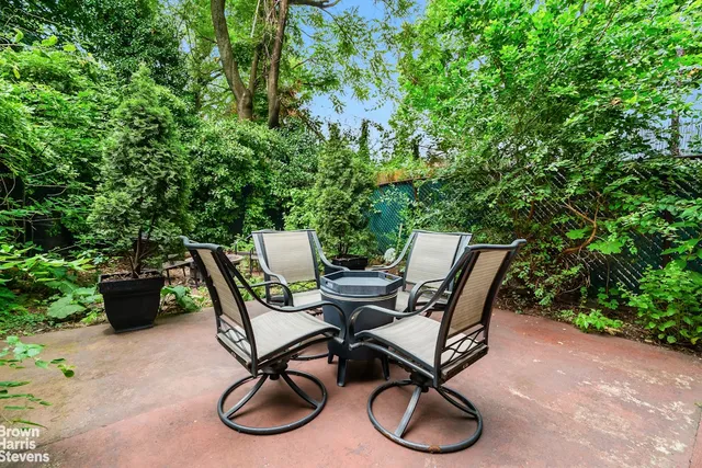 a backyard of a house with fountain table and chairs