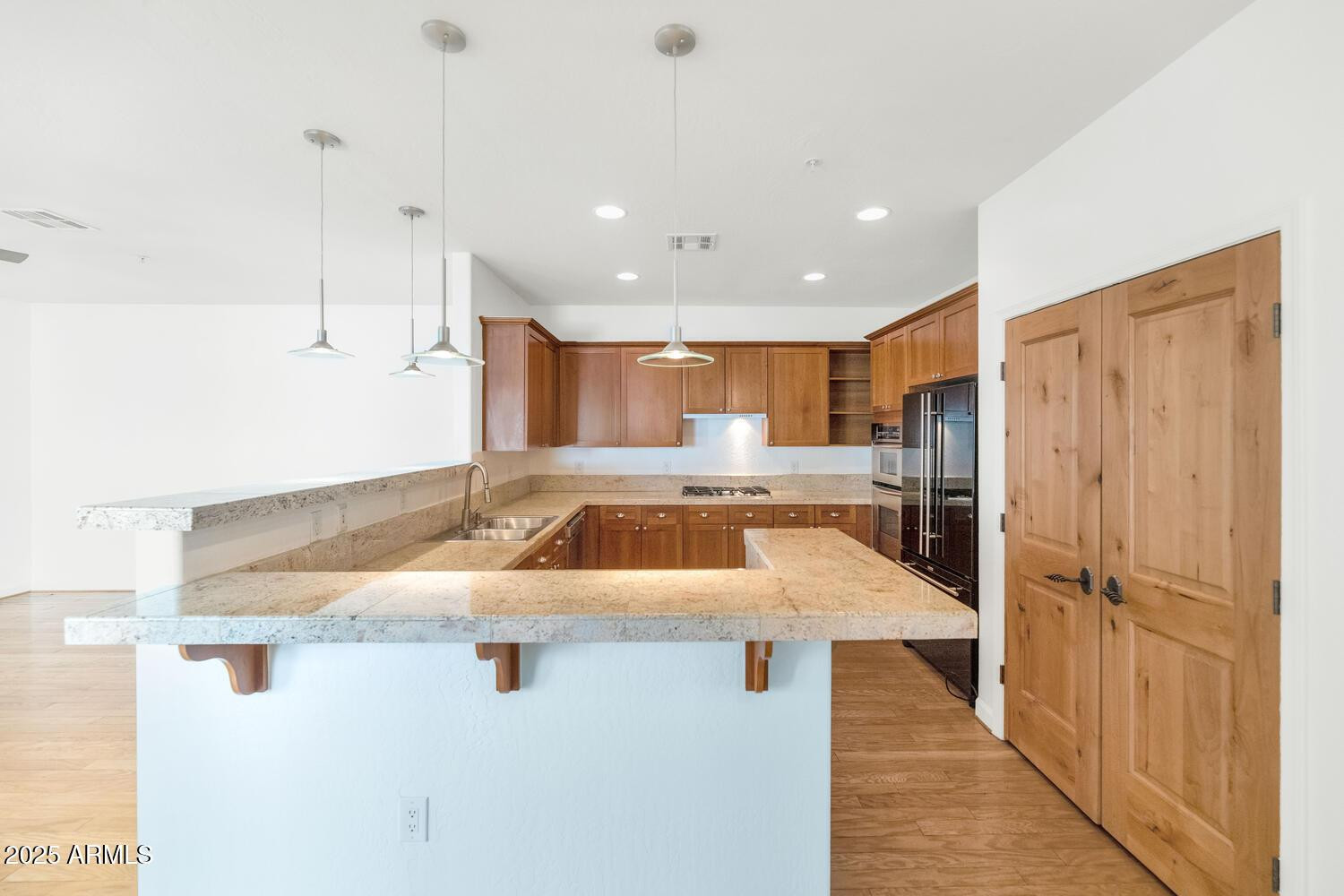 229 West Portland Street Phoenix, AZ 85003 - Photo 11 of 26 a kitchen with stainless steel appliances kitchen island granite countertop a refrigerator and a sink