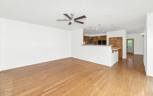 a view of a kitchen with wooden floor and a ceiling fan