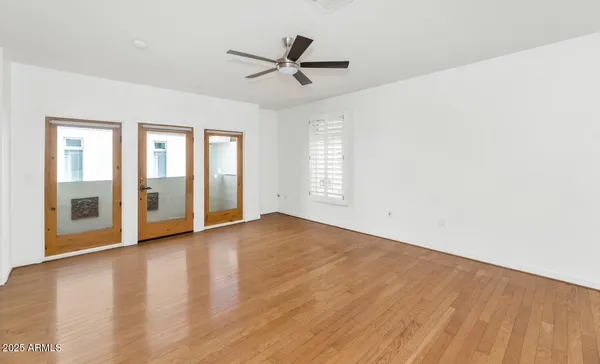 an empty room with wooden floor and windows