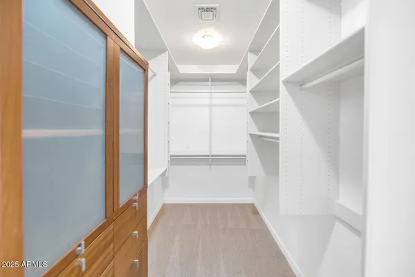 a view of walk in closet with empty racks