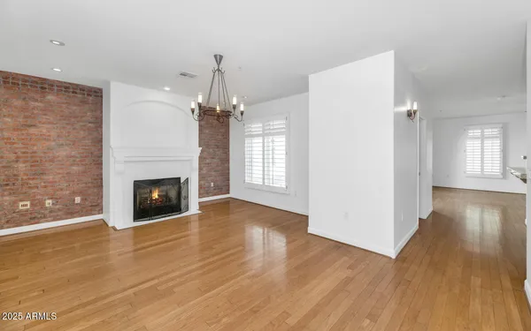 a view of a livingroom with wooden floor and a fireplace