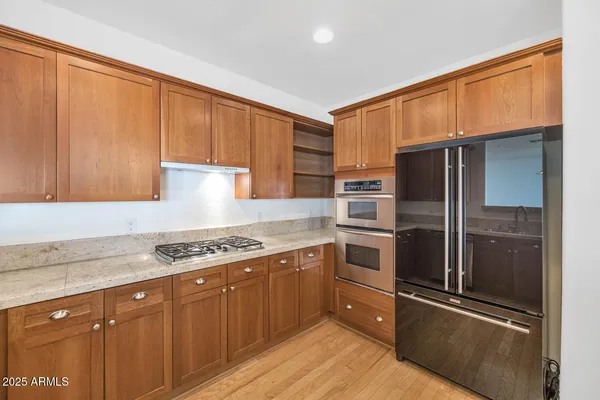 a kitchen with granite countertop stainless steel appliances and wooden cabinets