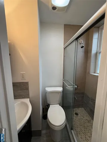 a bathroom with a granite countertop toilet sink and a shower
