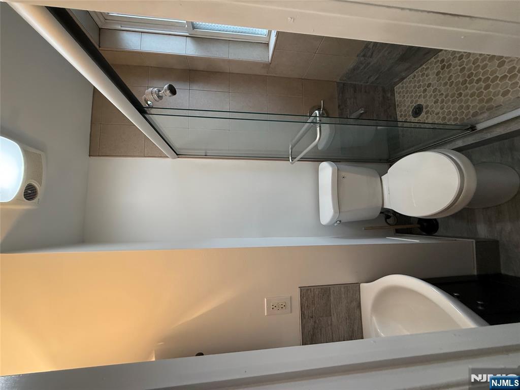 207 Westervelt Place, Unit 2 Lodi, NJ 07644 - Photo 11 of 13 a bathroom with a granite countertop toilet sink and a shower