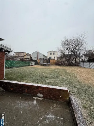 a view of a yard with wooden fence