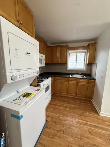 a kitchen with a sink a stove cabinets and a window