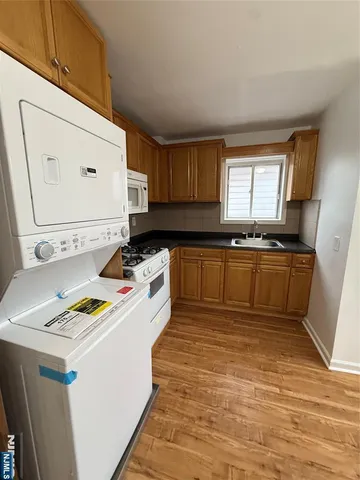 a kitchen with a sink a stove cabinets counter space and a window