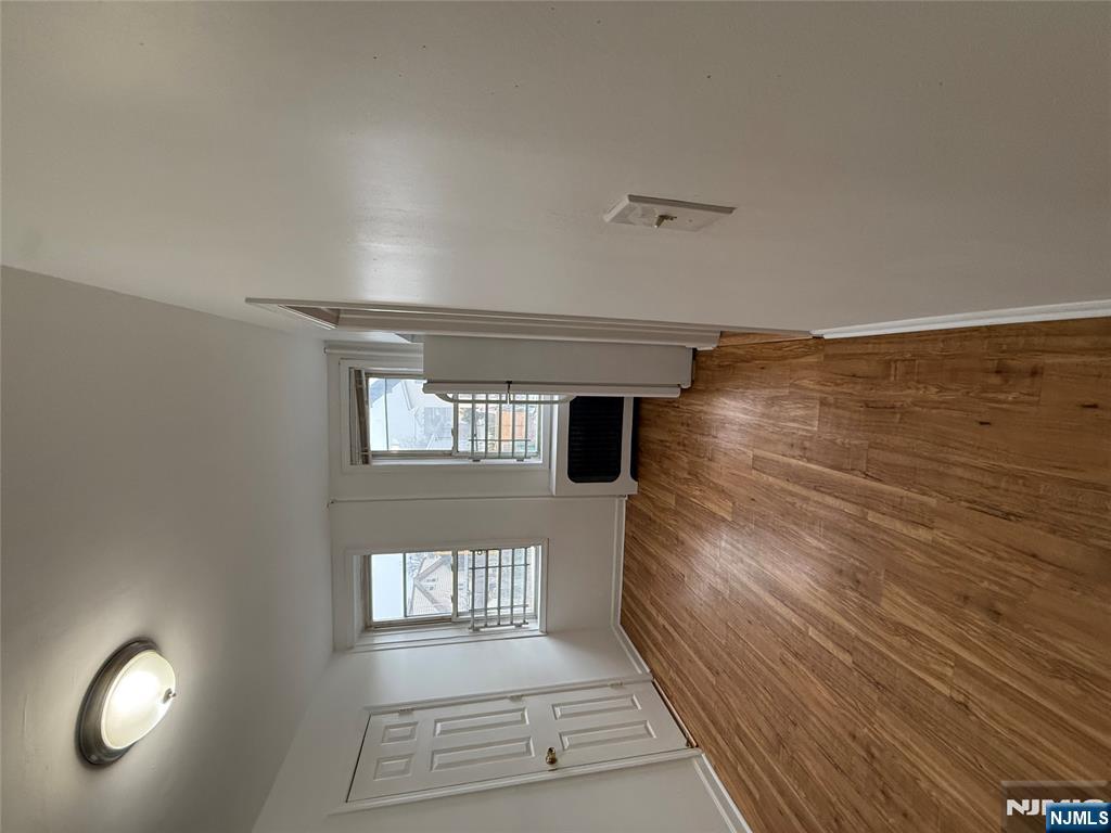 207 Westervelt Place, Unit 2 Lodi, NJ 07644 - Photo 5 of 13 an empty room with wooden floor and windows