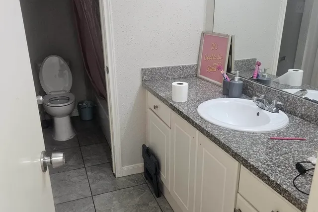 a bathroom with a granite countertop sink and a mirror