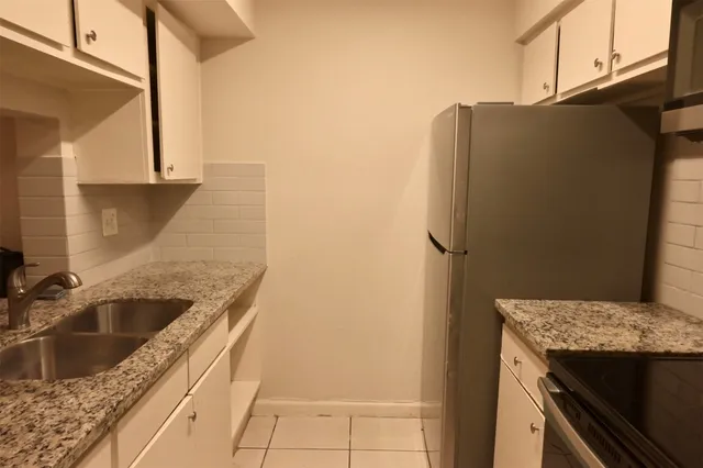 a kitchen with stainless steel appliances granite countertop a sink and a refrigerator