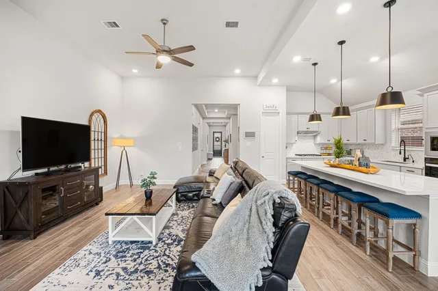 a kitchen with stainless steel appliances a table chairs refrigerator and microwave