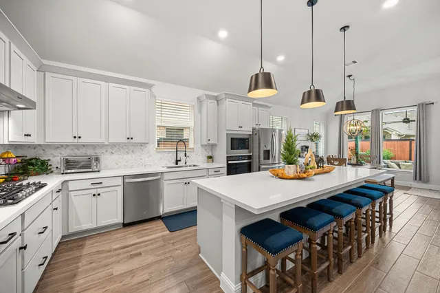 a kitchen with stainless steel appliances white cabinets and a sink