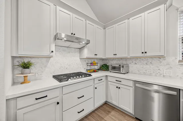 a kitchen with a sink stove and wooden floor