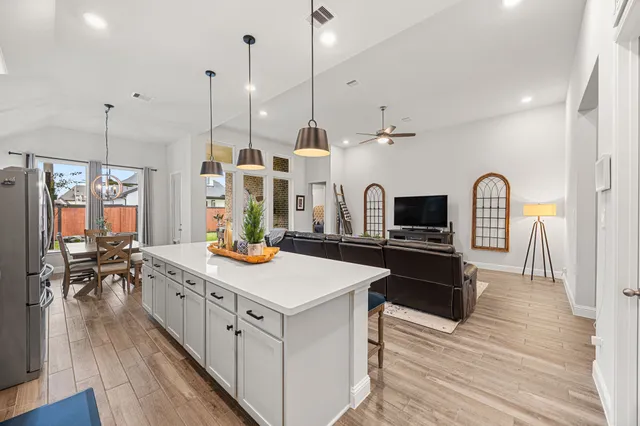 a kitchen that has a lot of cabinets in it and wooden floors
