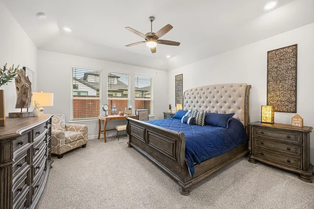 a bedroom with a large bed and a chandelier