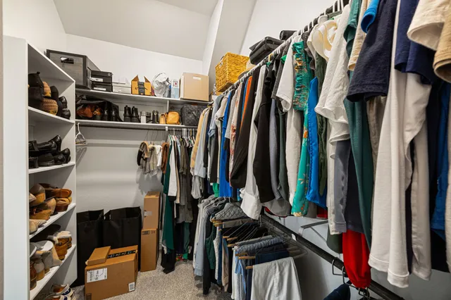 a view of walk in closet with clothes and shoes