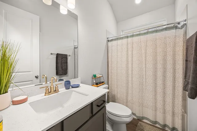 a bathroom with a toilet a sink and mirror