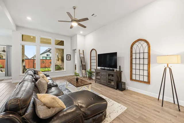 a living room with furniture a flat screen tv and kitchen view