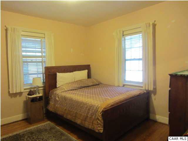 201 Cleveland Avenue Charlottesville, VA 22903 - Photo 6 of 13 a bedroom with a bed and wooden floor