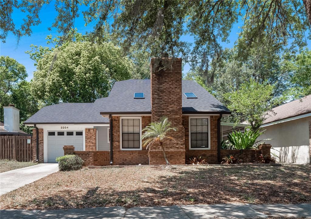 a front view of a house with a tree