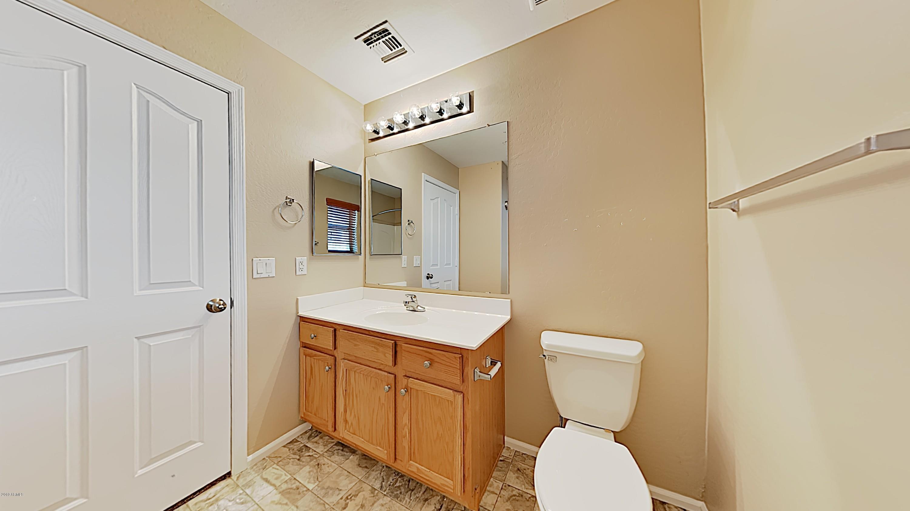 43905 Roth Road Maricopa, AZ 85138 - Photo 13 of 16 a bathroom with a toilet sink and mirror