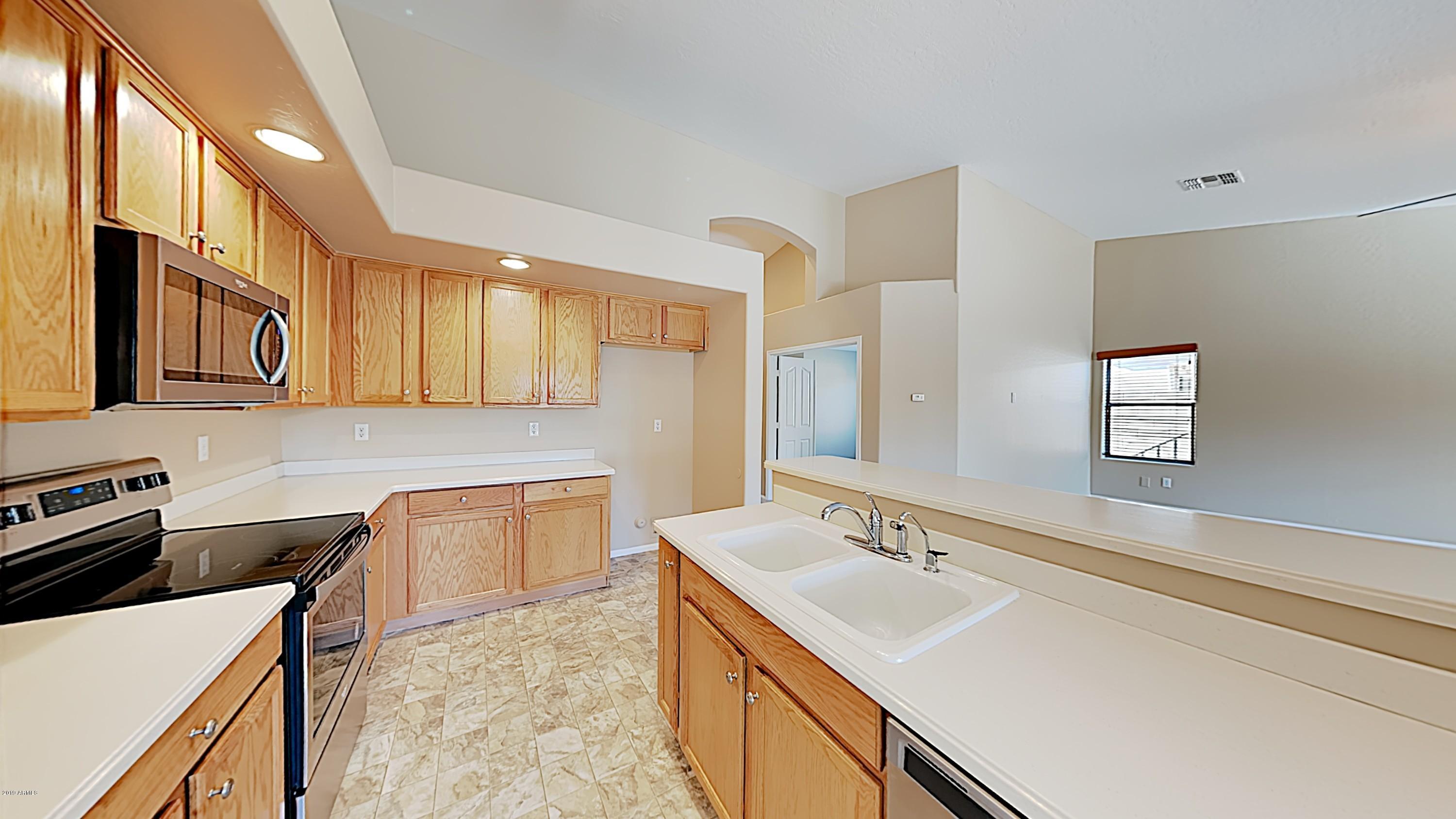 43905 Roth Road Maricopa, AZ 85138 - Photo 7 of 16 a kitchen with a sink stove top oven and cabinets