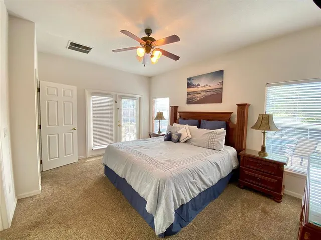 a bedroom with a bed a chandelier and a flat tv screen