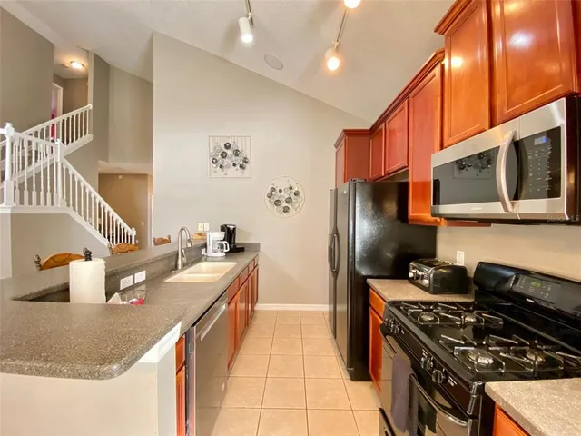 a kitchen with stainless steel appliances granite countertop a refrigerator and a stove
