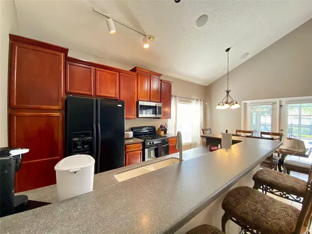 a dining hall with stainless steel appliances a dining table and chairs