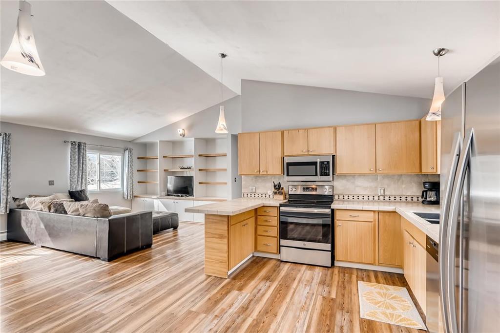 125 Reiling Road Breckenridge, CO 80424 - Photo 1 of 35 a kitchen with stainless steel appliances a stove top oven a sink dishwasher a refrigerator and white cabinets with wooden floor