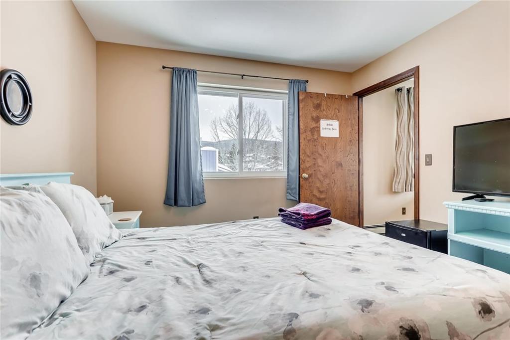 125 Reiling Road Breckenridge, CO 80424 - Photo 23 of 35 a bedroom with a large bed and a flat tv screen on dresser
