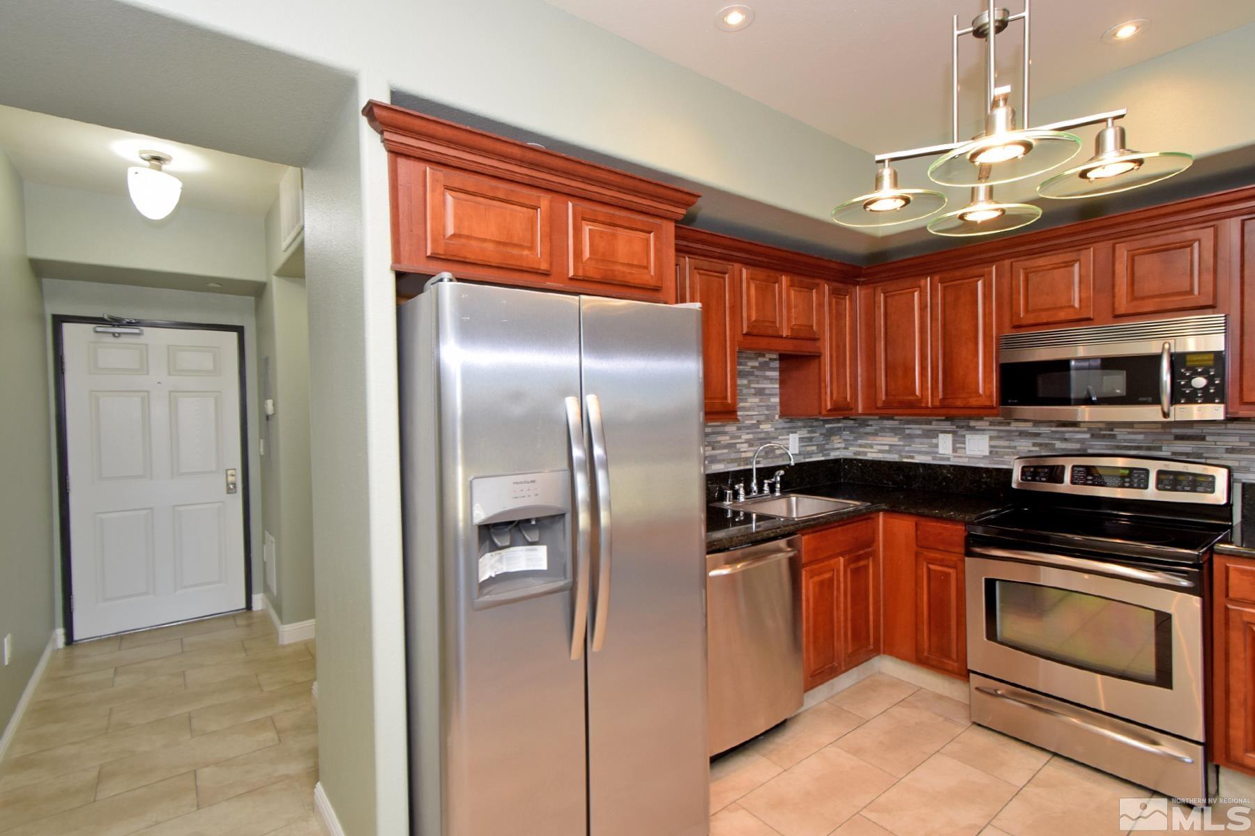 200 West 2nd Street, Unit 1108 Reno, NV 89501 - Photo 3 of 16 a kitchen with stainless steel appliances granite countertop a refrigerator stove and oven