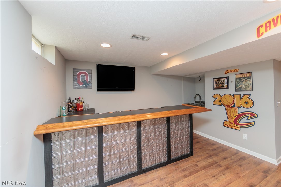 5630 Oak Point Road Lorain, OH 44053 - Photo 34 of 44 Bar with sink and hardwood / wood-style floors