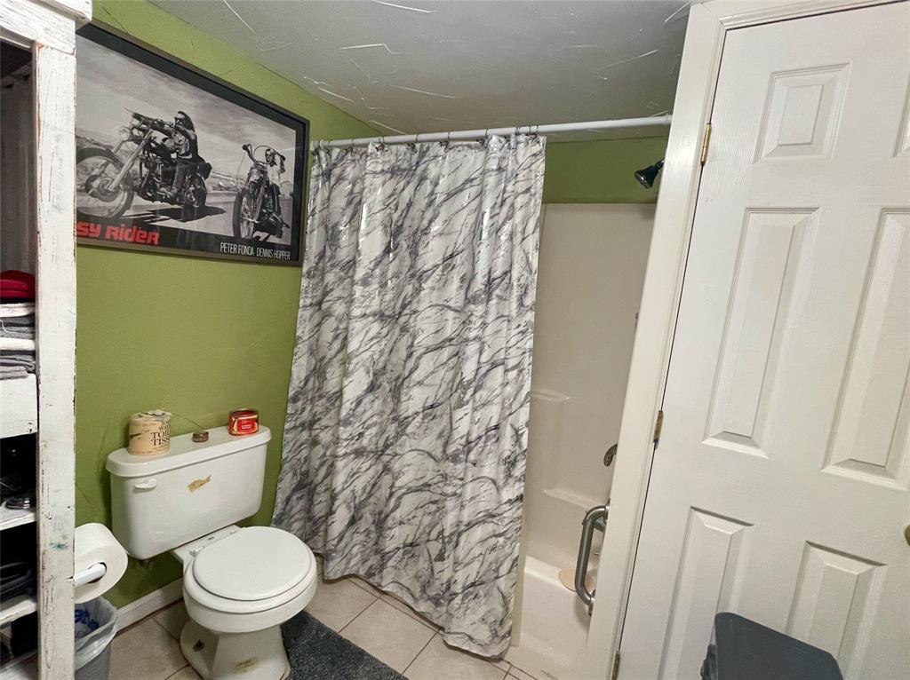 2334 San Bar Road, Unit 13 Graford, TX 76449 - Photo 22 of 33 a white toilet sitting next to a shower curtain