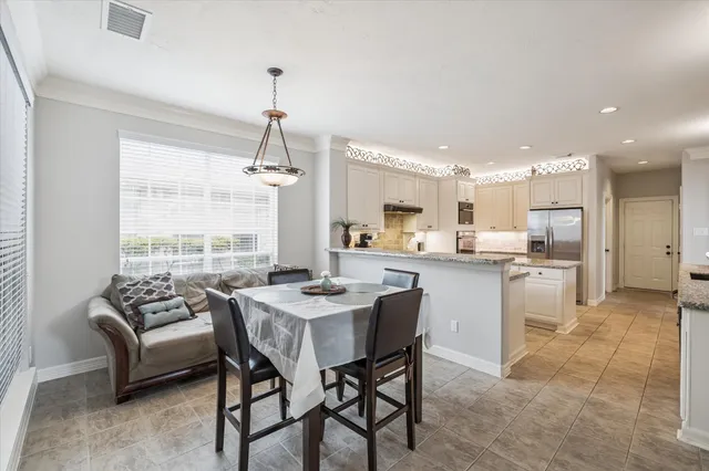 a kitchen with a dining table chairs sink and cabinets