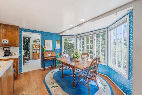 a kitchen with a stove a sink a refrigerator dining table and chairs