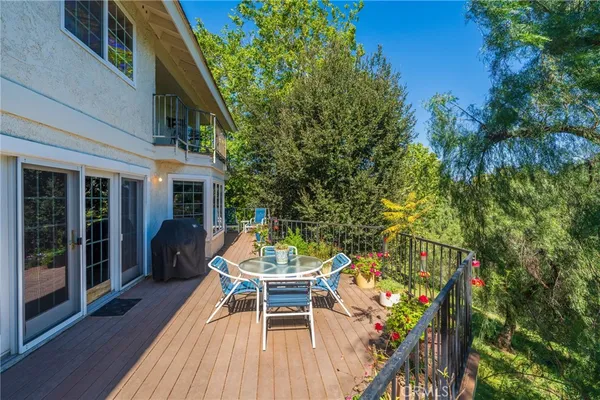 a balcony with wooden floor and outdoor seating