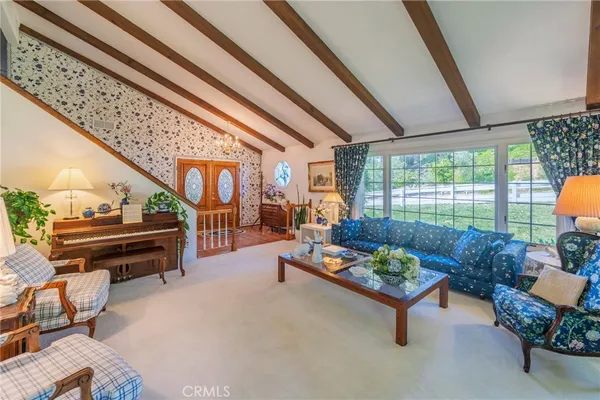 a living room with furniture fireplace and a large window