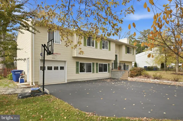 a view of a white house with a large tree